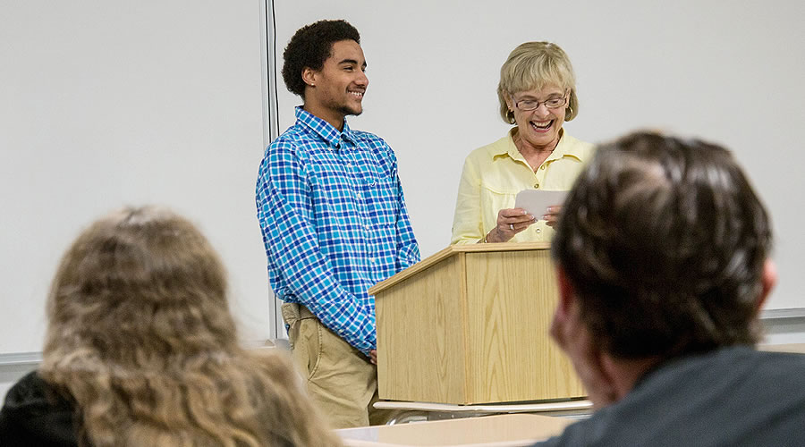 Faculty working with student in front of class