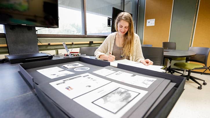 Student mounting print pieces in the portal portfolio classroom.