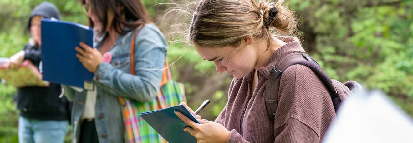 A group of first-year FLCC student taking notes while exploring FLCC's main campus.